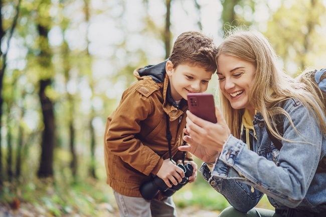 mère et son fils regarde cellulaire dans la foret