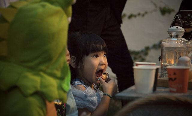 Une petite fille déguisée en princesse mange