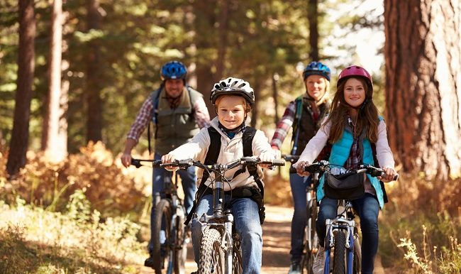 garçon qui fait du vélo de montage avec sa soeur et ses parents