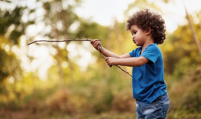 enfant qui joue avec des bâtons