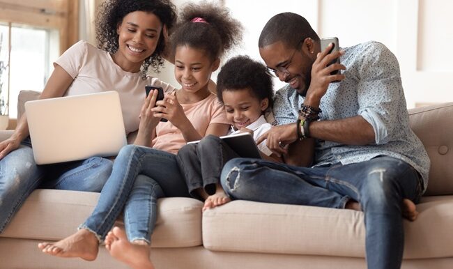 Happy addicted to gadgets black family using different devices.