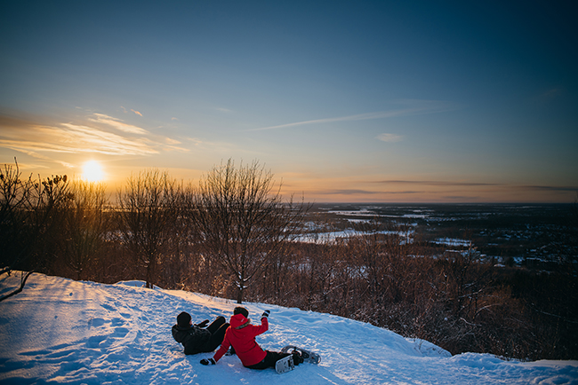 gens qui regardent le coucher du soleil en hiver