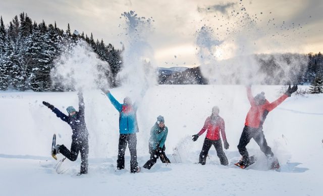 gens heureux pratiquant la raquette à neige