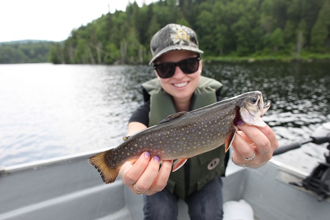 Femme dans une chaloupe montrant un poisson