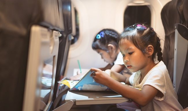 2 fillettes asiatiques qui dessinent durant un voyage en avion